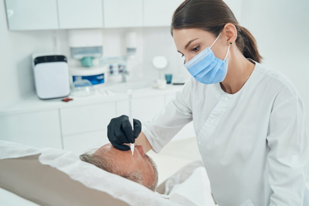 Cosmetologist performing cleansing skincare procedure in clinic